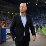 Jess Thorup wandelt na een wedstrijd langs de zijlijn van KRC Genk.