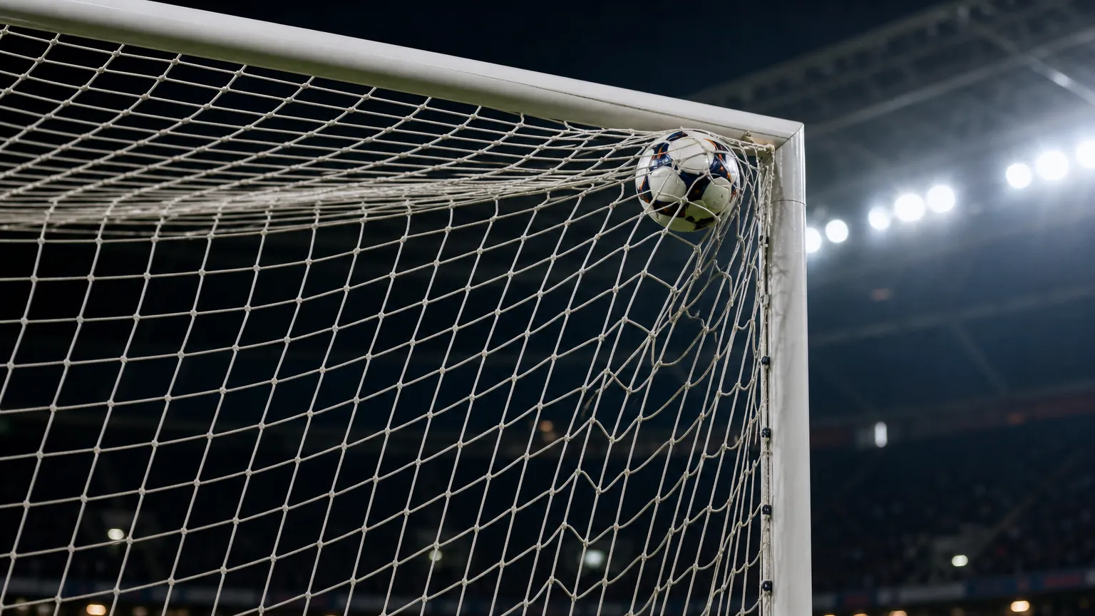 Een voetbal vliegt hoog in de hoek van het doel tijdens een wedstrijd.