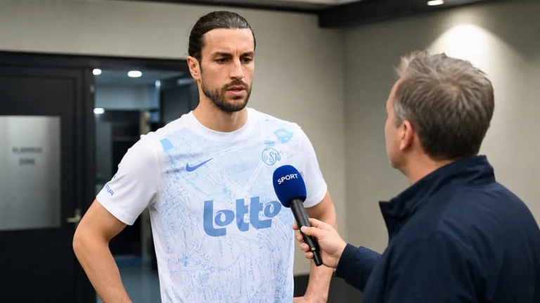 Christian Burgess spreekt in een stadionruimte voor een wedstrijd.