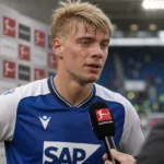 Nathan De Cat spreekt na een Bundesliga-wedstrijd in zijn Hoffenheim-tenue met een journalist.