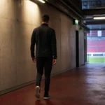 Een niet-herkenbare voetballer van achteren in een stadiontunnel van Royal Antwerp FC.