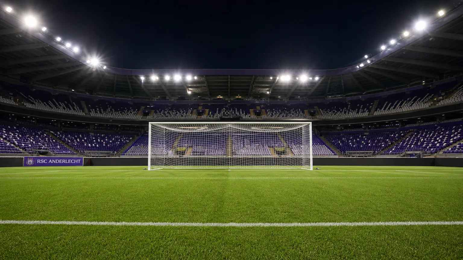 Leeg doelgebied in een verlicht stadion met een discreet RSC Anderlecht-bord langs het veld.