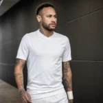 Neymar wandelt in een witte voetbaluitrusting door een stadiongangerij.