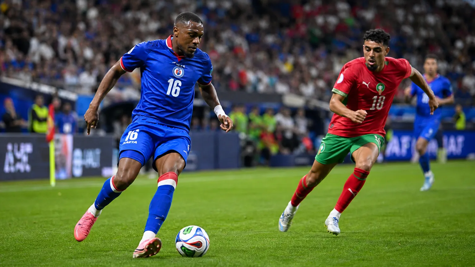 Lenny Joseph in blauw tenue tijdens een interland op een voetbalveld.