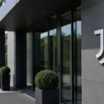 Ingang van een Juventus-clubgebouw met een discreet Juventus-embleem.
