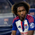 Malick Fofana zit geconcentreerd in de dug-out in zijn Lyon-tenue.
