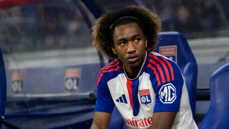 Malick Fofana zit geconcentreerd in de dug-out in zijn Lyon-tenue.