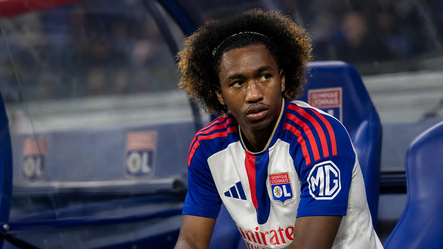 Malick Fofana zit geconcentreerd in de dug-out in zijn Lyon-tenue.