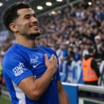 Zakaria El Ouahdi in een blauw shirt aan de rand van het veld.
