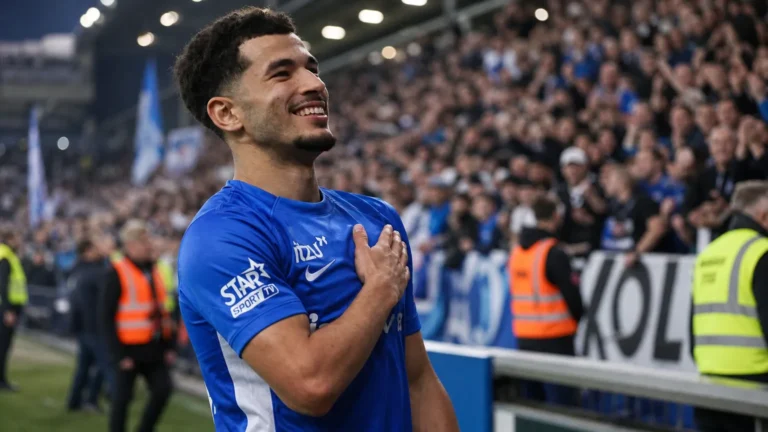 Zakaria El Ouahdi in een blauw shirt aan de rand van het veld.