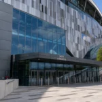 De ingang van het Tottenham Hotspur Stadium met een discreet clubembleem.