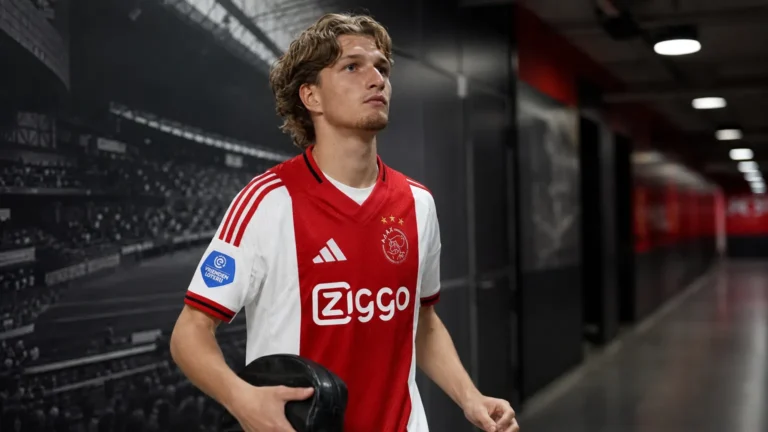 Mika Godts in Ajax-tenue tijdens een wandeling door een stadionganger.