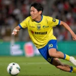 Een STVV-speler in geel tijdens een duel op de Bosuil.