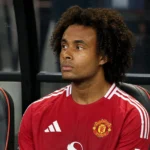 Joshua Zirkzee zit op de bank van Manchester United naast het veld.