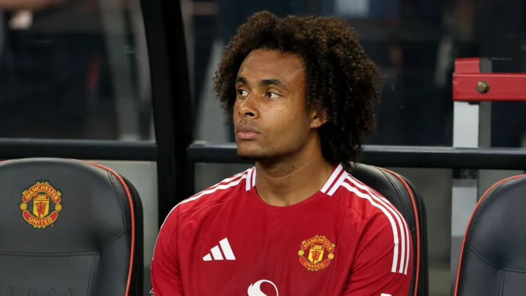 Joshua Zirkzee zit op de bank van Manchester United naast het veld.