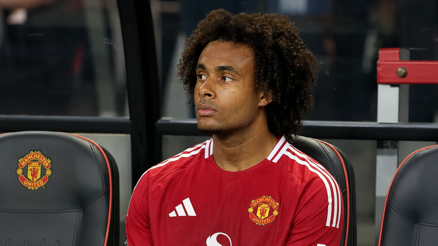 Joshua Zirkzee zit op de bank van Manchester United naast het veld.