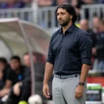 Marvin Compper langs de zijlijn in een donker hemd.