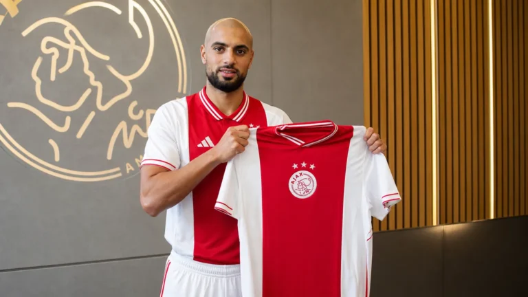 Sofyan Amrabat toont een Ajax-shirt tijdens een officiële clubpresentatie.