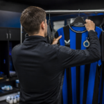 Een Club Brugge-shirt hangt aan een rek in een materiaalruimte.