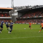 Brede wedstrijdfoto van Dundee United-spelers op het veld.