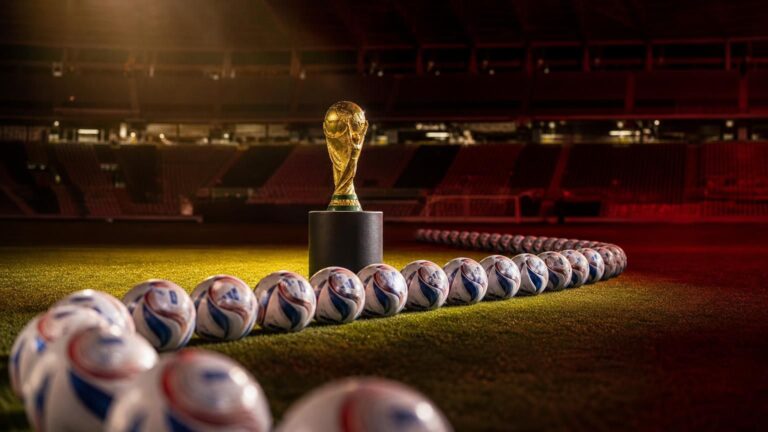 WK-trofee tussen een overvloed aan ballen in een gespannen, leeg stadion