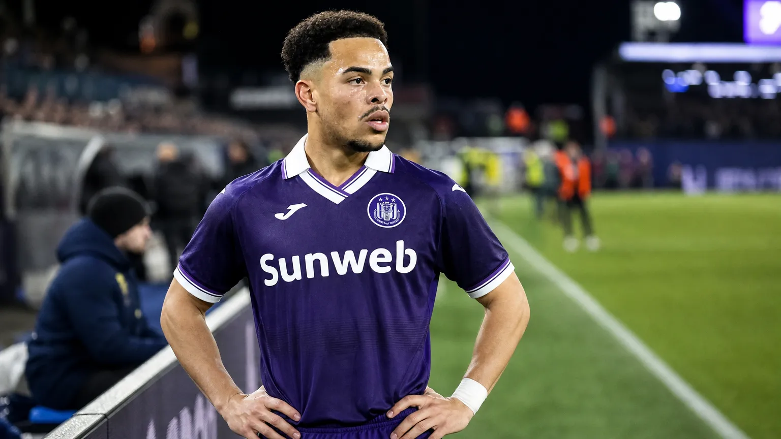 Mario Stroeykens van Anderlecht staat aandachtig aan de rand van een voetbalveld.