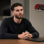 Wesley Hoedt zit in neutrale kleding in een rustige vergaderruimte met een discreet AZ-wanddetail.