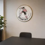 Werkruimte in het clubgebouw van Sparta Rotterdam met een discreet embleem aan de wand.