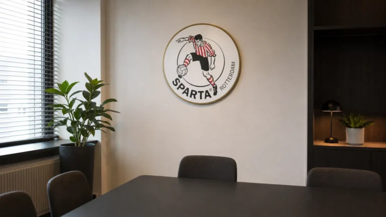 Werkruimte in het clubgebouw van Sparta Rotterdam met een discreet embleem aan de wand.