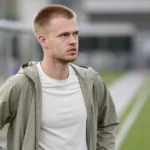 Arthur Vermeeren in neutrale sportkleding naast een trainingsveld.