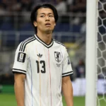 Keito Nakamura in het witte shirt van Japan aan de zijlijn van een voetbalveld.