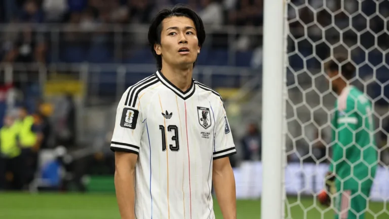 Keito Nakamura in het witte shirt van Japan aan de zijlijn van een voetbalveld.