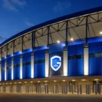 De ingang van de Cegeka Arena met een discreet KRC Genk-clubembleem bij valavond.