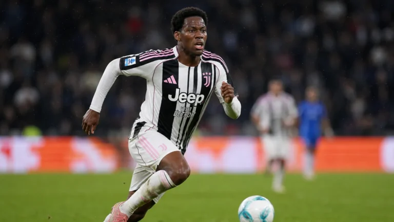 Jonathan David in een zwart-wit gestreept tenue tijdens een voetbalwedstrijd.