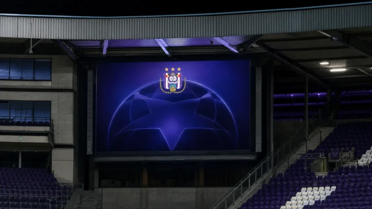 Een verlicht bord in het Lotto Park met het embleem van RSC Anderlecht tijdens een Europese voetbalavond.