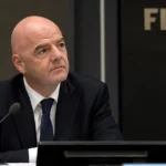 Gianni Infantino luistert aandachtig in een FIFA-congreszaal.