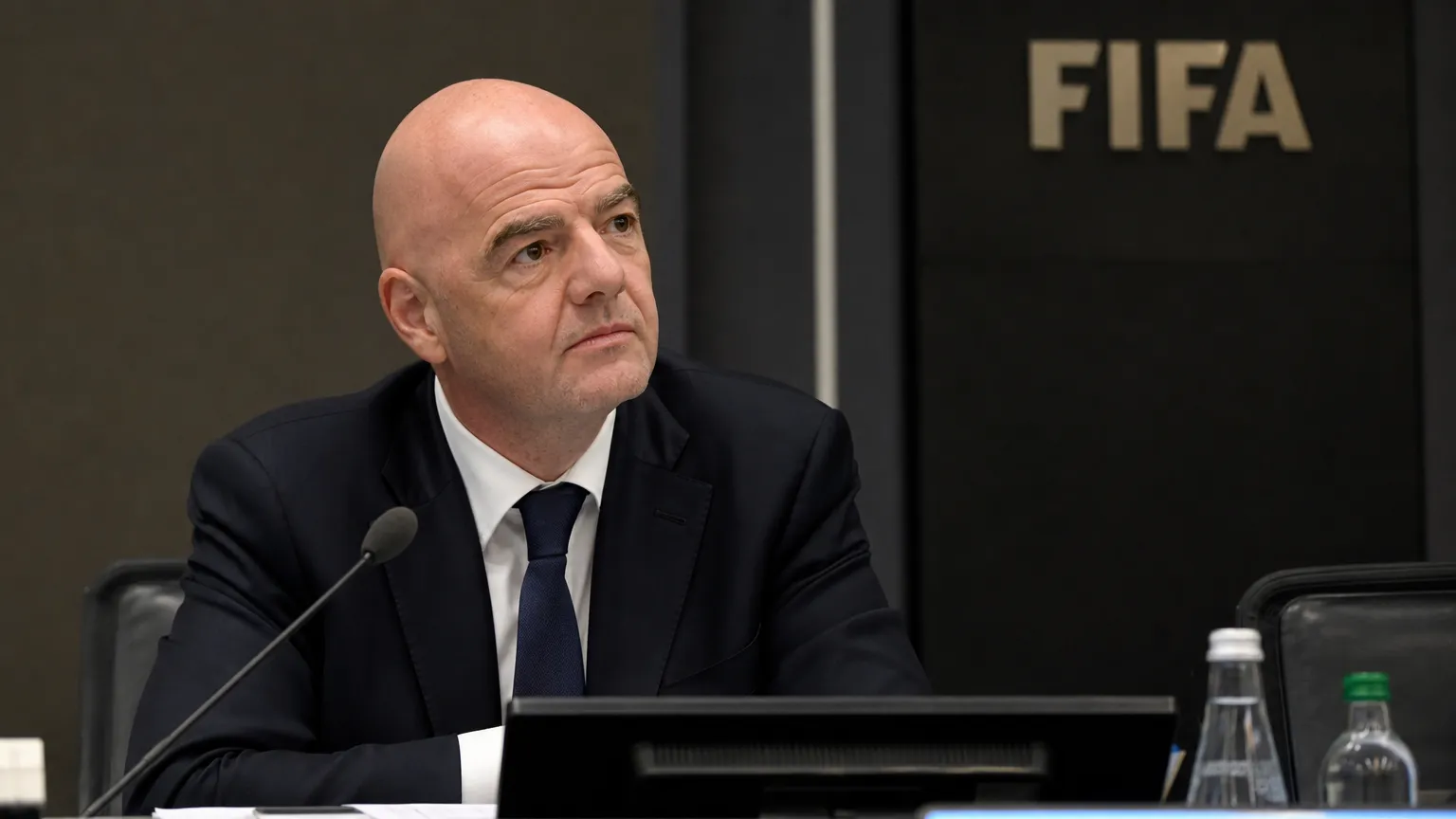 Gianni Infantino luistert aandachtig in een FIFA-congreszaal.
