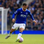 Iliman Ndiaye in blauw tenue tijdens een voetbalactie op het veld.