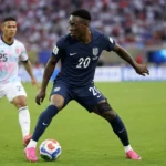Folarin Balogun in een donkerblauw tenue van de Verenigde Staten aan de bal tijdens een wedstrijd.
