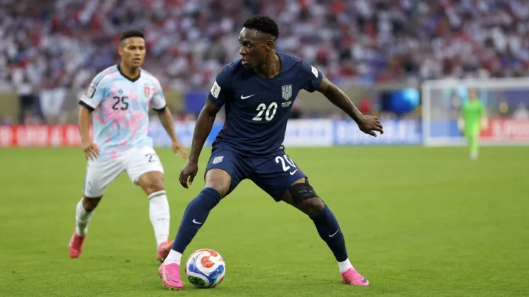 Folarin Balogun in een donkerblauw tenue van de Verenigde Staten aan de bal tijdens een wedstrijd.
