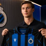 Freddie Potts poseert met een Club Brugge-shirt in een indoor mediasetting.