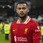Cody Gakpo in Liverpool-tenue aan de rand van een verlicht voetbalveld.