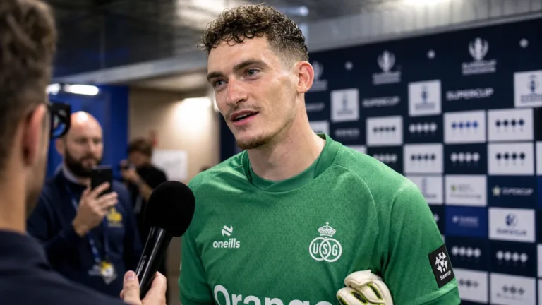 Vic Chambaere spreekt na een wedstrijd met verslaggevers in groene keeperskleding.