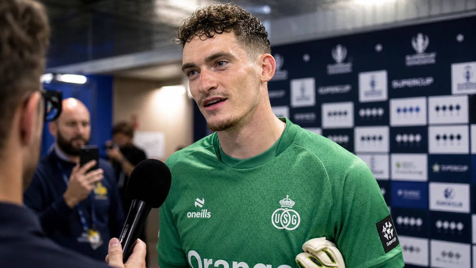 Vic Chambaere spreekt na een wedstrijd met verslaggevers in groene keeperskleding.