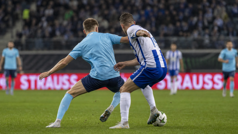 Anonieme voetballers in een duel tijdens een gespannen Europese wedstrijd.