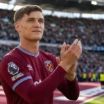 Freddie Potts applaudisseert in het shirt van West Ham United op het veld.