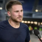 Kevin Mac Allister spreekt na de wedstrijd in een stadionzone met een verslaggever.