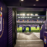 De verlichte spelerstunnel van RSC Anderlecht in een operationele stadionomgeving.
