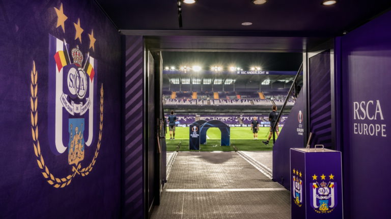 De verlichte spelerstunnel van RSC Anderlecht in een operationele stadionomgeving.