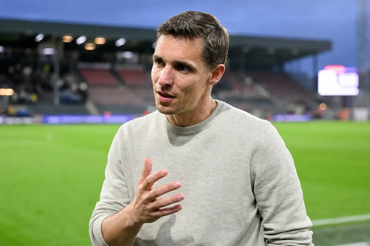 David Hubert in een grijze trui tijdens een interview naast het veld in Oostende.
